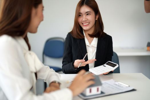 Real estate agent or bank officer describes the loan interest to the customer with home purchase contracts or on office loans and interest rates