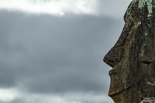Profile detailed view of Moai head against cloudy sky