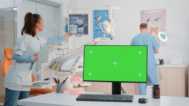 Monitor with green screen on desk in dentist office for dental checkup and oral care. Computer with horizontal chroma key and mockup template for dentition treatment and teethcare