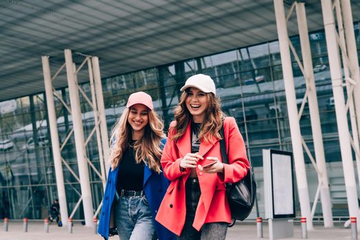 Two happy girls walking near airport. Air travel, summer holiday. Communication