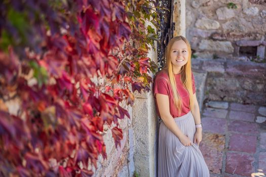 Woman tourist on background of beautiful view of the island of St. Stephen, Sveti Stefan on the Budva Riviera, Budva, Montenegro. Travel to Montenegro concept.