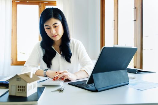 Entrepreneurs, business owners, accountants, real estate agents, Portrait of asian women who use the home buying budget calculator to calculate their financial risks