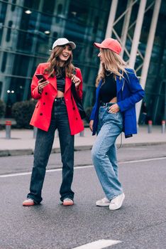 Two happy girls walking near airport. Air travel, summer holiday. Communication