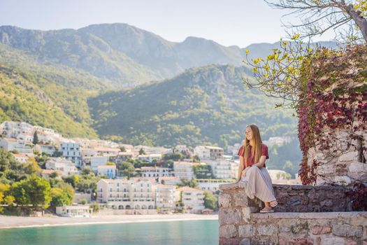 Woman tourist on background of beautiful view of the island of St. Stephen, Sveti Stefan on the Budva Riviera, Budva, Montenegro. Travel to Montenegro concept.