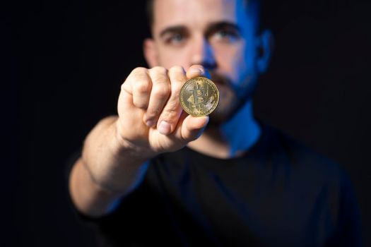 Golden bitcoin coin in a businessman hand. Digitall symbol of a new virtual currency. Man holds bitcoins