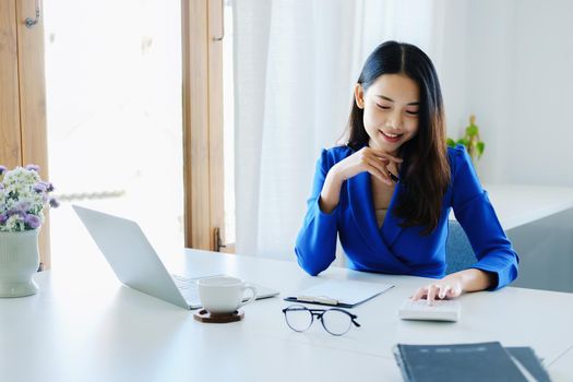 Accountants, business executives, auditors, economists, Portrait of Asian business women are using calculators to calculate financial statements and investments to assess risks for companies