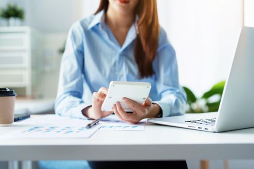Auditor, Self-Employed, Finance, Investment, tax and budget, Asian female entrepreneur using a calculator to calculate. Company business results document