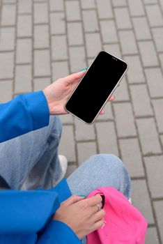 Cropped shot view of woman's hands holding smart phone with blank copy space screen for your text message or information content, female reading text message.