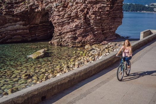 Woman tourist on a bicycle explores Budva in Montenegro. Cycling in Montenegro concept.