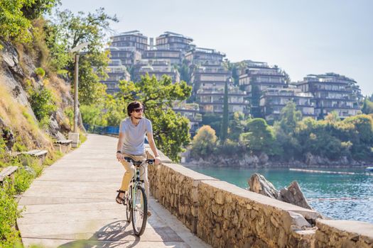 Man tourist on a bicycle explores Budva in Montenegro. Cycling in Montenegro concept.