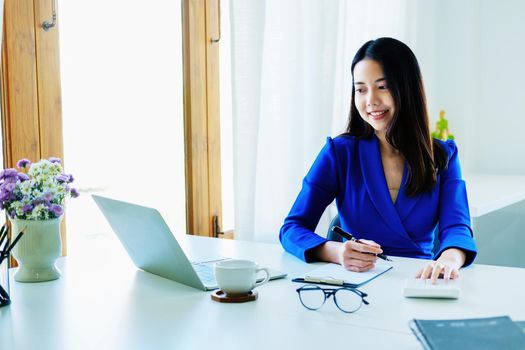 Accountants, business executives, auditors, economists, Portrait of Asian business women are using calculators to calculate financial statements and investments to assess risks for companies