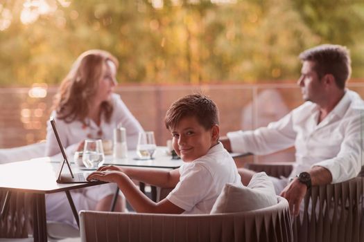 An elderly couple enjoys the terrace of a luxury house with their son during the holidays. Selective focus. High-quality photo