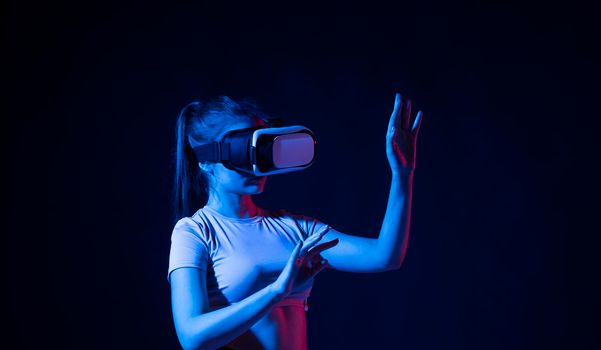 Portrait of female architector wearing virtual reality headset and making gestures with hands, she uses VR technology for industrial design, development, architecting