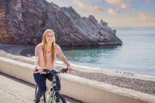 Woman tourist on a bicycle explores Budva in Montenegro. Cycling in Montenegro concept.