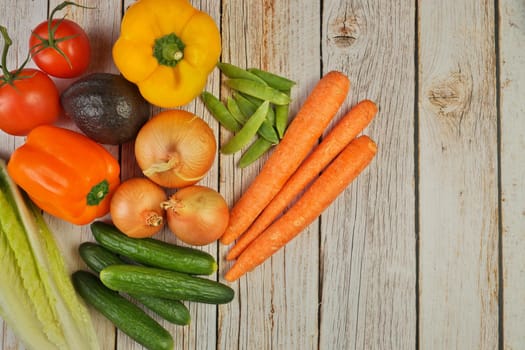 Directly Above Flat Lay View of a Variety of Fresh Summer Garden Vegetables on a Rustic Wooden Table with Copy Space on Right