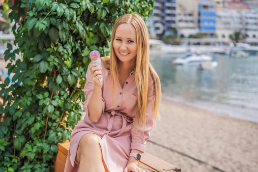 Close up of pretty tourist girl eating traditional gelato italian ice cream in a European town.