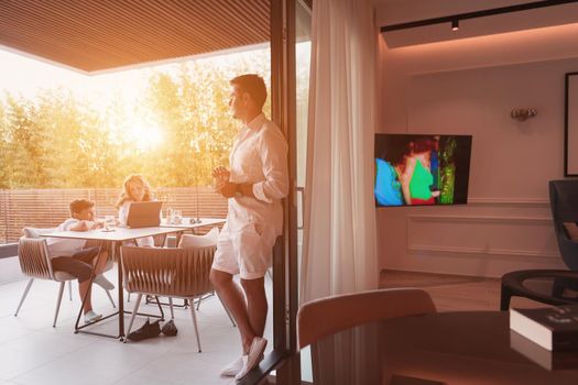 An elderly couple enjoys the terrace of a luxury house with their son during the holidays. Selective focus. High-quality photo