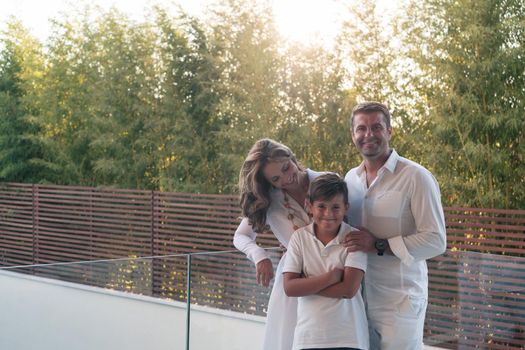 Happy family resting on the balcony of a luxury house surrounded by forest nature. Selective focus. High-quality photo