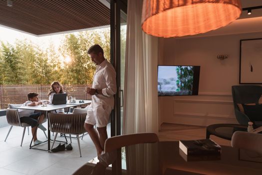 An elderly couple enjoys the terrace of a luxury house with their son during the holidays. Selective focus. High-quality photo