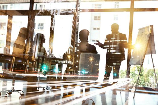 Shot of a city superimposed over a group of businesspeople having a presentation in the boardroom.