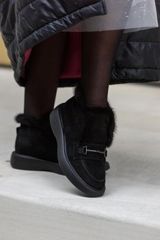 Female fashion shoes. Black boots with fur.