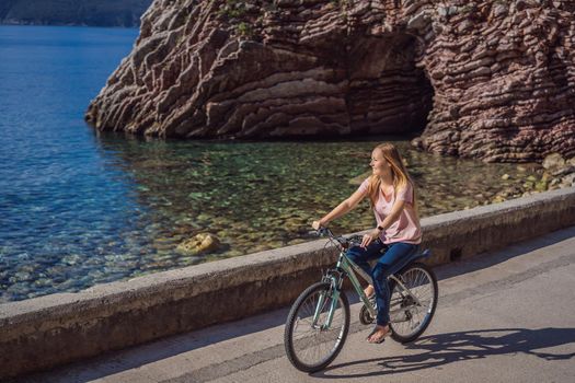 Woman tourist on a bicycle explores Budva in Montenegro. Cycling in Montenegro concept.