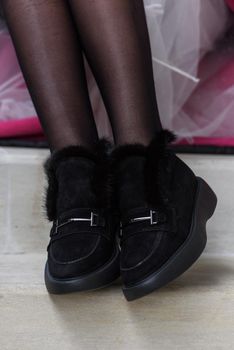 Female fashion shoes. Black boots with fur.