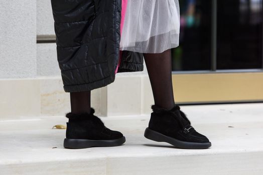 Female fashion shoes. Black boots with fur.