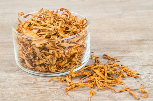 The Dried cordyceps militaris mushroom flower on wooden background.