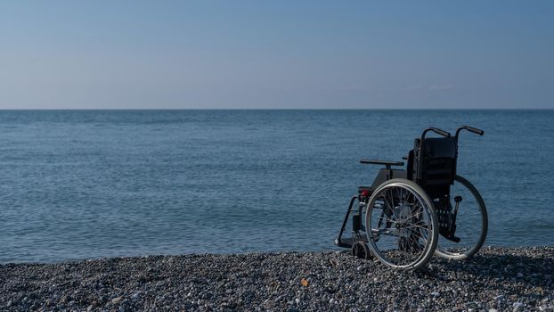 An empty wheelchair on a rocky seashore