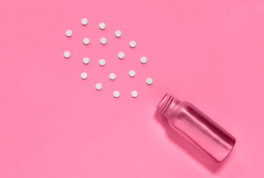 White pills and pink medicine bottle  on pink background , hearth care  and medicine