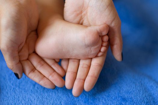 Hands of mother in the form of a heart on children's legs