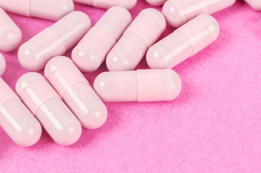 The Pink capsule pills on pink background