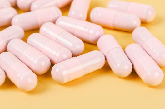 The Pink capsule pills on yellow background