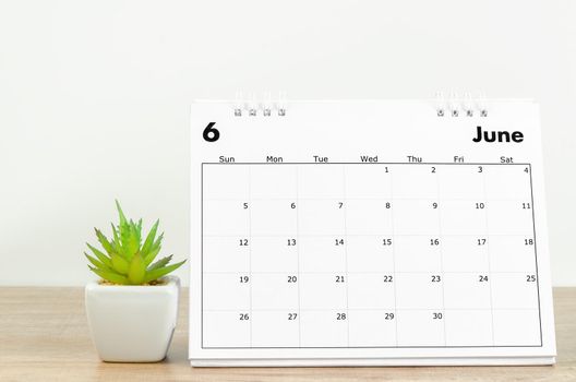 The June 2022 desk calendar on wooden background.