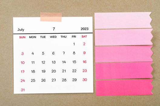 The July 2022 calendar with blank adhesive note paper on brown background.
