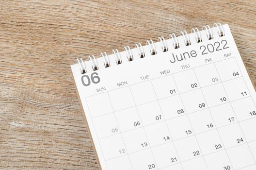 The June 2022 desk calendar on wooden background.