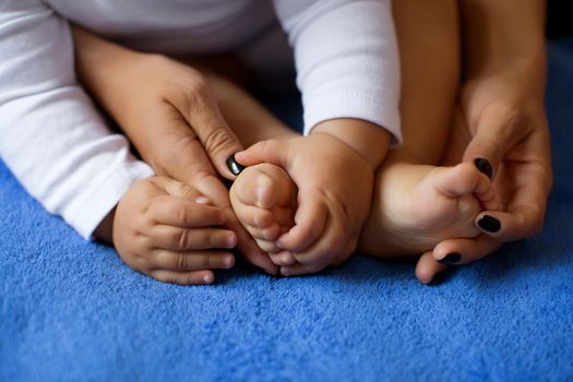 Hands of mother in the form of a heart on children's legs