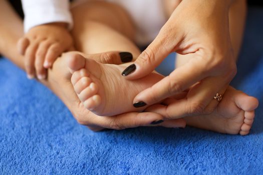 Hands of mother in the form of a heart on children's legs