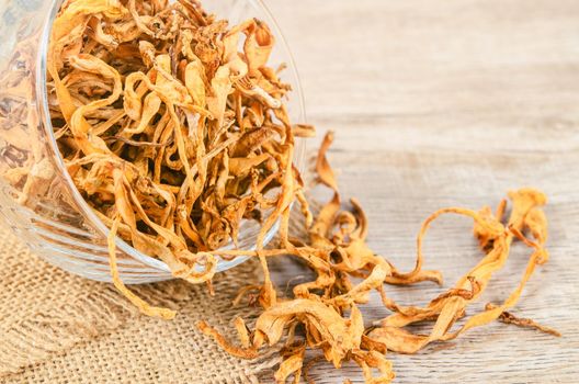 The Dried cordyceps militaris mushroom flower on wooden background.
