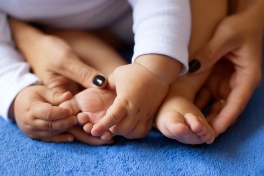 Hands of mother in the form of a heart on children's legs