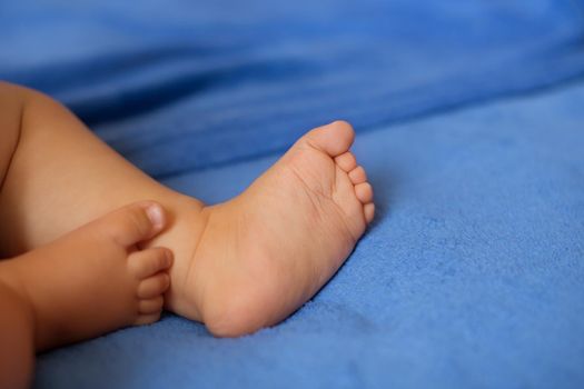 Children's legs on a blue veil close-up