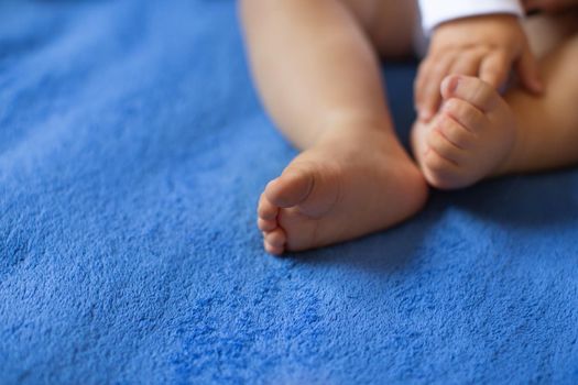 Children's legs on a blue veil close-up