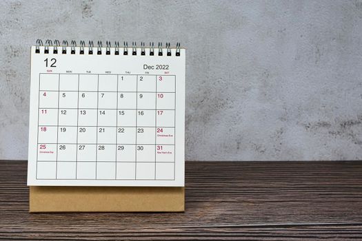 December 2022 white calendar on wooden desk. Celebration date and copy space.