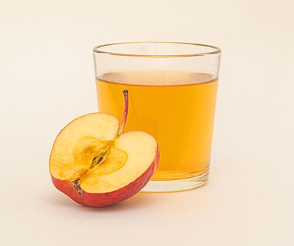 a glass of apple juice and a half of red apple isolated on white background