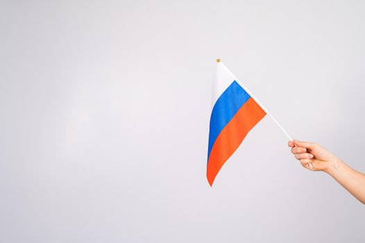 Woman holding a small flag of the Russian Federation on a white background