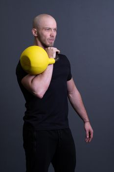 Guy with a yellow kettlebell gym anonymous workout strength, in the afternoon sporty teenager for strong from resitance weightlifting, asian fitness. Healthy down endurance, club hiit