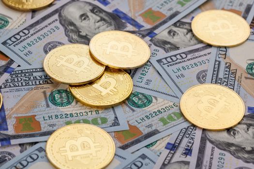 yellow bitcoin coins scattered over US dollar paper banknotes, cryptocurrency and fiat money exchange concept