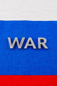 the word war laid with silver metal letters on Russian Federation tricolor flag - full-frame view