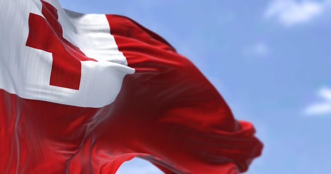 Detail of the national flag of Tonga waving in the wind on a clear day. Tonga is a Polynesian country and also an archipelago. Selective focus.